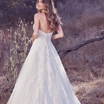 Vestido de novia línea A de encaje con escote corazón. Terminado con botones cubiertos sobre cierre de cremallera y corsé.
