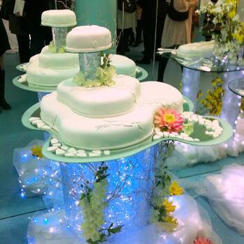 Tarta nupcial de diseño presentada en tres pisos y con flores