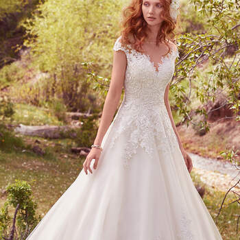 This romantic ballgown features lace appliqués across the bodice, illusion sweetheart neckline, illusion back, and regal hemline. Subtle crosshatch details and sequins add shimmer and dimension. Finished with covered buttons over zipper and inner corset closure. 
<a href="https://www.maggiesottero.com/maggie-sottero/lena/10120?utm_source=mywedding.com&amp;utm_campaign=spring17&amp;utm_medium=gallery" target="_blank">Maggie Sottero</a>