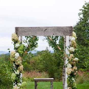 Estructura de madera con flores y telares blancos. Una opción siempre romántica!