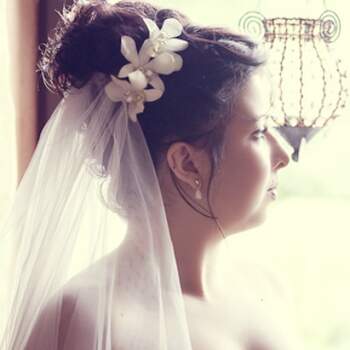 Hochgesteckte Brautfrisur mit Blumen-Accessoire. Foto: www.yourphoto.de