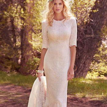 Elegant and demure, this allover lace fit-and-flare features 
elbow-length sleeves and a classic jewel neckline. Lined with Inessa jersey, and accented with a frayed scalloped hemline and back ruching. Finished with covered buttons over zipper closure. 
<a href="https://www.maggiesottero.com/maggie-sottero/mckenzie-marie/10163?utm_source=mywedding.com&amp;utm_campaign=spring17&amp;utm_medium=gallery" target="_blank">Maggie Sottero</a>