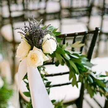 Lavande, roses blanches et branchages : une association parfaite pour la décoration des chaises. Crédit photo : Lisa Lefkowitz Photography