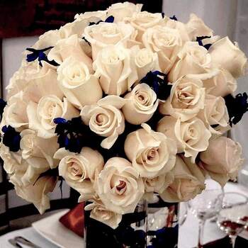 Arreglo floral para mesa con rosas beige y matizadas con otra variedad en azul oscuro. 
