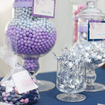 Mesa de dulces en colores violetas, azules y plateados lucen tentadores para tus invitados. 