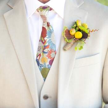 Corbata floreada con fondo marfil, a juego con el chaqué, y ramillete de flores amarillas. Foto: Gillet Photography