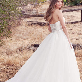 Classic and enchanting, this strapless tulle ballgown features a soft sweetheart neckline with beaded lace motifs accenting the subtly ruched bodice and band of Yaron Mikado at the waist. Finished with crystal buttons over zipper and inner corset closure. 
