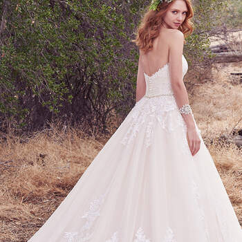 Gorgeous lace appliqués cascade over the bodice and hemline of this strapless tulle ballgown, featuring a soft scoop neckline and soft V-back. A bead and Swarovski crystal belt adds a touch of shimmer. Finished with covered buttons over zipper and inner elastic closure.
