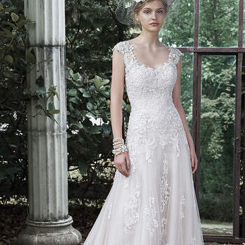 A stunning A-line, this tulle wedding gown is adorned with exquisite lace cascading the bodice and full skirt. Finished with illusion lace cap-sleeves, illusion neckline, and crystal buttons over zipper closure.

<a href="http://www.maggiesottero.com/dress.aspx?style=5MB650" target="_blank">Maggie Sottero</a>
