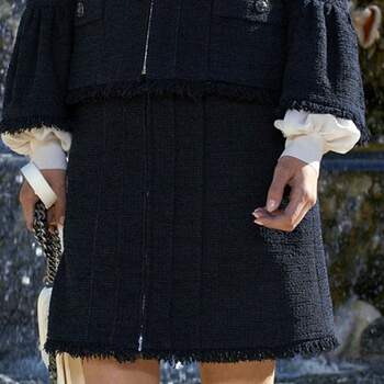 Las mangas de la camisa sobresalen por debajo de las chaquetas de 'tweed'. Foto: Chanel. 
