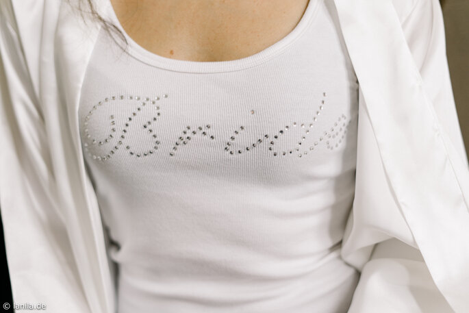 Braut trägt weißes Shirt mit Aufschrift "Bride"