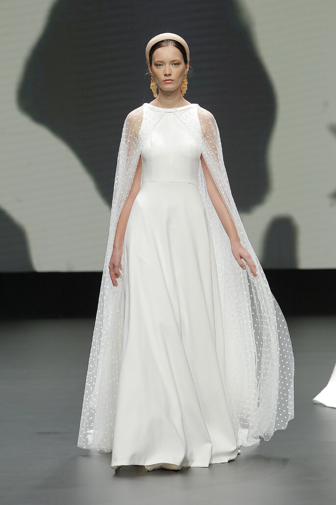 Colección Vestido de Novias 2021 Jesús Peiró vestido de novia con escote barco con capa larga de transparencia en los hombros