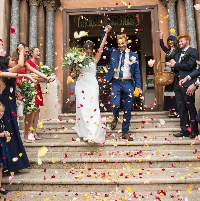 Les mariés à la sortie de la mairie sous un lancer de pétales de fleurs