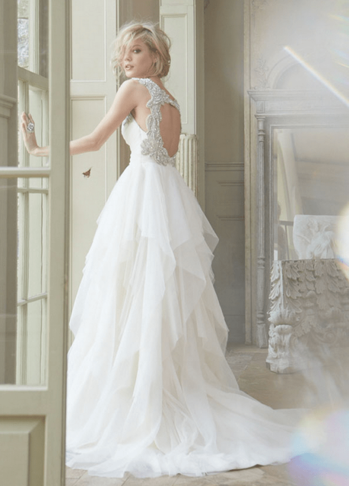 Vestido de novia corte princesa con cut outs en la espalda; falda confeccionada con tul y cauda larga - Foto Hailey Paige en JLM Couture