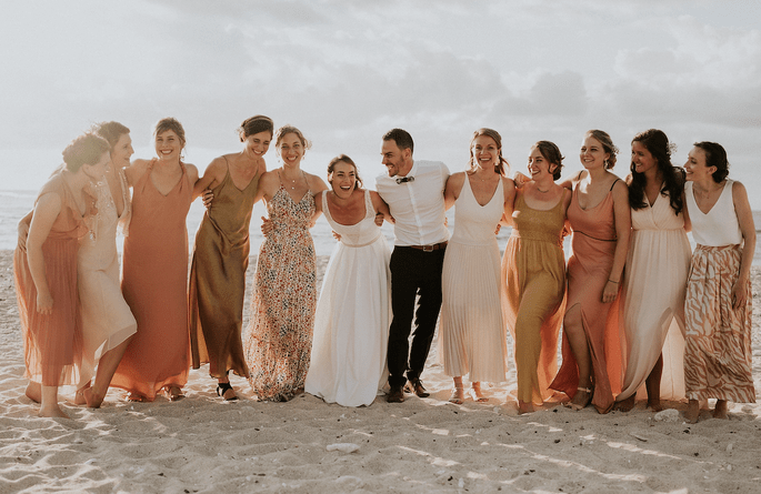 Les mariés entourés de leurs proches se retrouvent sur la plage dans un décor idyllique