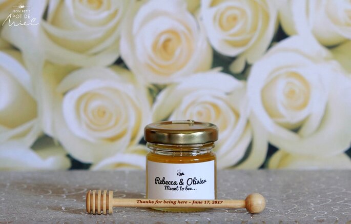 un petit pot de miel à disposer sur vos tables de mariage avec sa cuillère à miel 