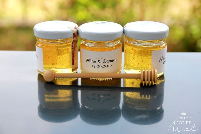 trois petits pots de miel transparents disposés sur une table 