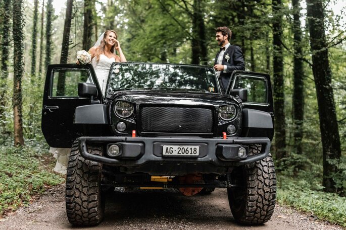 Hochzeitsfoto. Brautpaar auf Jeep im Wald