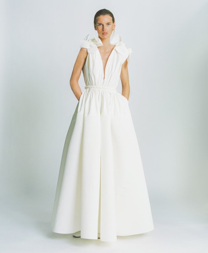 Robe de mariée avec un décolleté plongeant et plissé et deux noeuds sur les épaules 