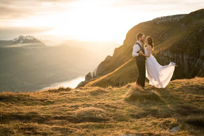 Brautpaar ausgelassen vor Bergen, fotografiert von Herzpaar