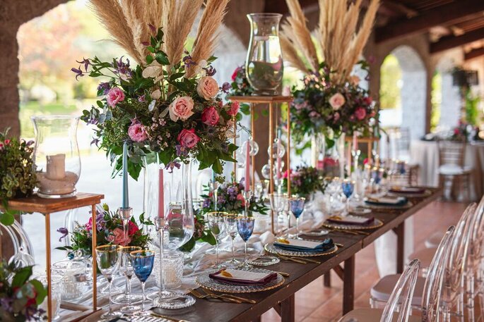 Apollinare Catering & Banqueting allestimento tavolata, fiori alti e papiri, bicchieri blu