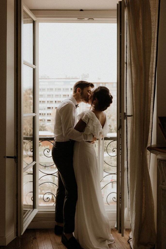 Un couple s'embrasse tendrement au balcon de leur chambre - Sara Ben Aziza