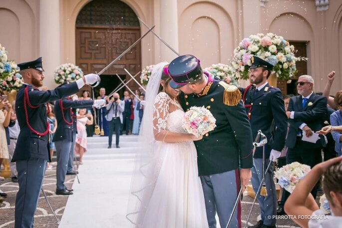 sposo in divisa che bacia una sposa