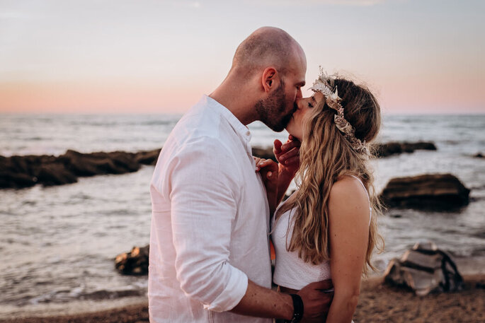Couple de mariés s'embrassant sur la plage
