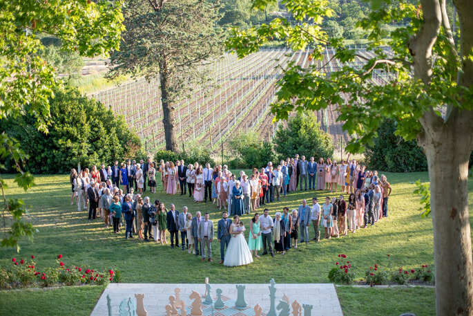 les invités de mariage posent dans le parc devant les vignes - Château de Malmont 
