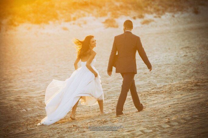 Coppia di sposi sulla spiaggia al tramonto