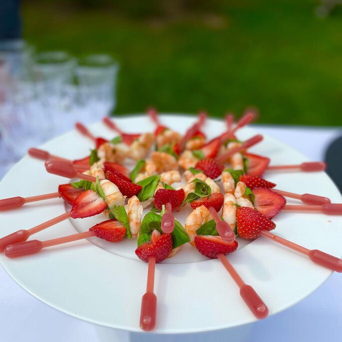 fraise et crevette en brochette présentées sur une pipette de sauce 
