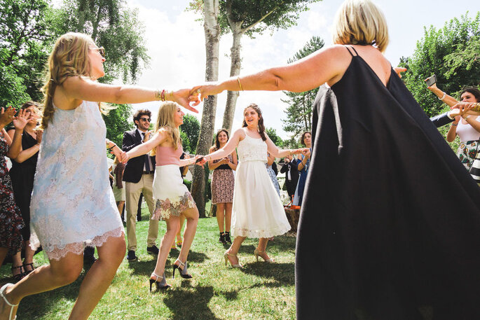 Julien Nguyen Kim - Photographie de mariage - Haut de Seine - des invités faisant la ronde en s'amusant dans un parc lors d'un mariage 