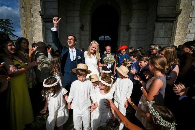 Des mariés à la sortie de l'église entourés de leurs invités