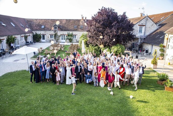 Des invités dans la cour d'un château en train de poser 