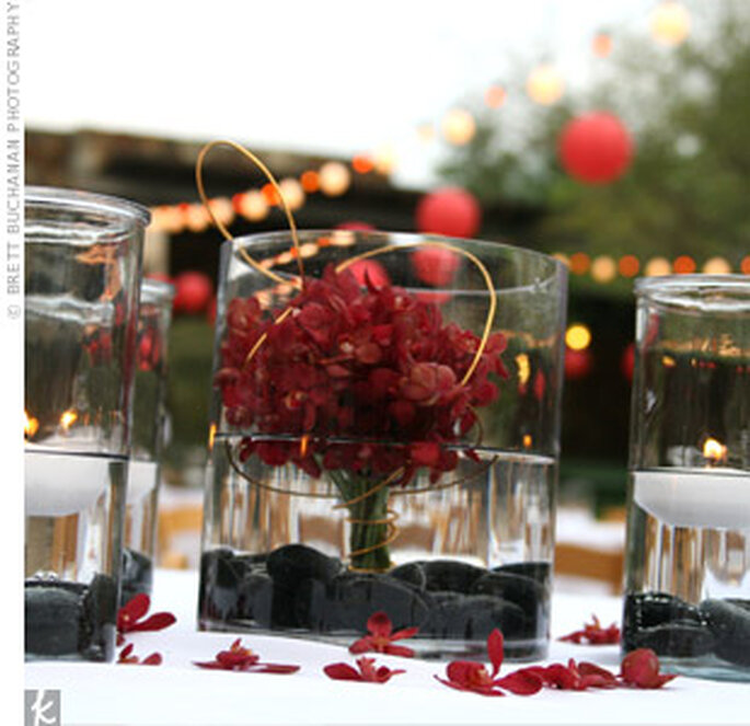 Un centro de mesa con ramo y pétalos rojos dan un aire de distinción.