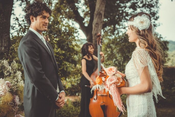 sposi boho chic con violoncellista su sfondo
