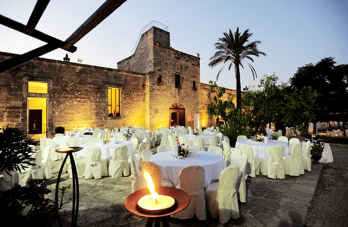 Masseria San Lorenzo, facciata illuminata con allestimento tavoli tondi