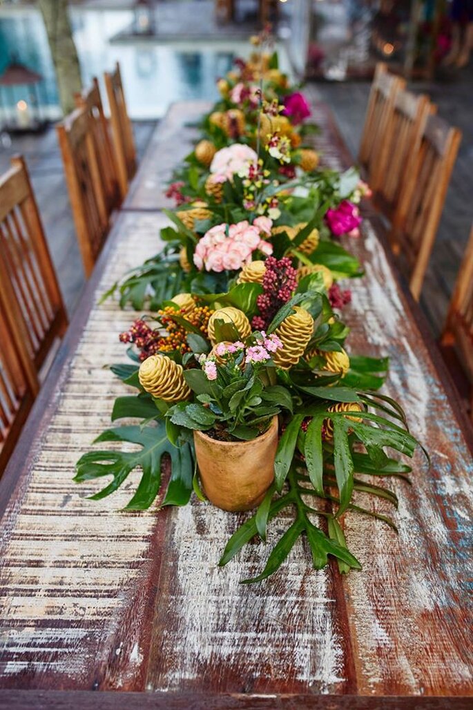 Mesa de convidados com plantas e flores.