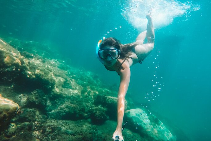 Mulher mergulhando em Angra dos Reis em lua de mel barata no Brasil