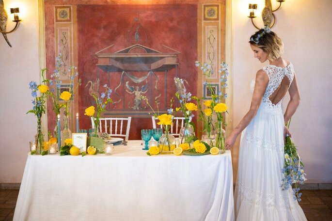 sposa al tavolo dedicato, decorato di giallo con fiori e limoni
