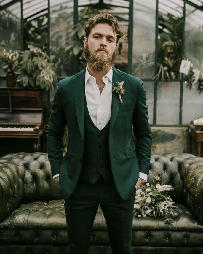 traje de novio en color verde sin corbata ni moño con chaleco verde y adorno floral