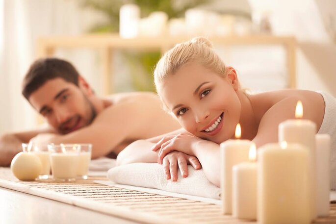 Pareja de novios relajados en un spa con velas