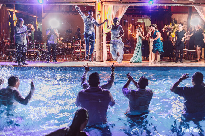 Noivos se jogam na piscina no meio da festa