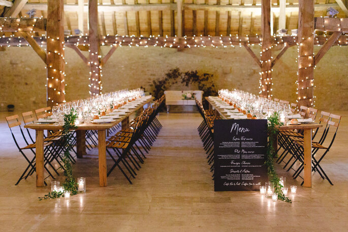 Salle de mariage décorée avec des tables en bois et des guirlandes guinguettes