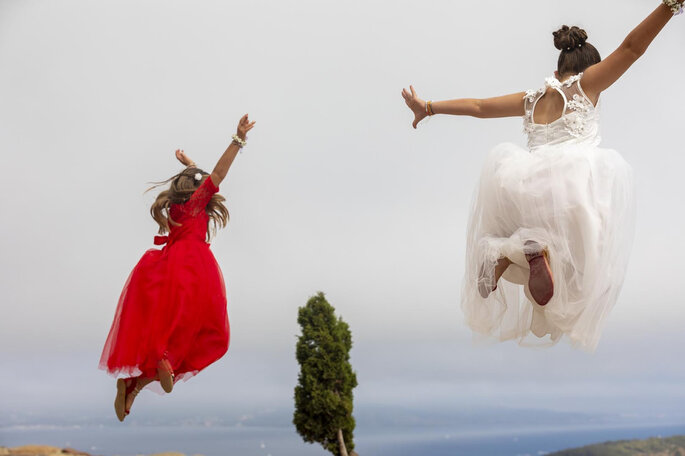 Une mariée prise en photo en plein saut aux côtés d'une de ses invitées