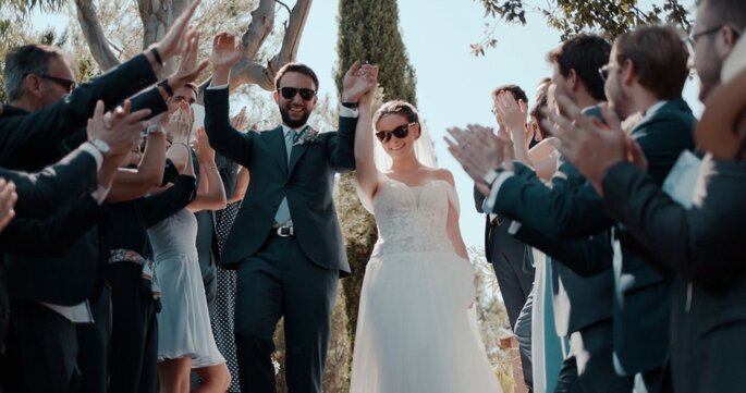 Les mariés équipés de lunettes de soleil sous les ovations de leurs invités