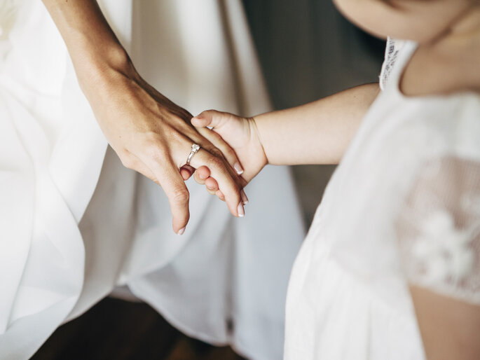 Patricia Bara Photography - petite fille qui tient la main de la future mariée avec sa bague de fiancaille et un diamant