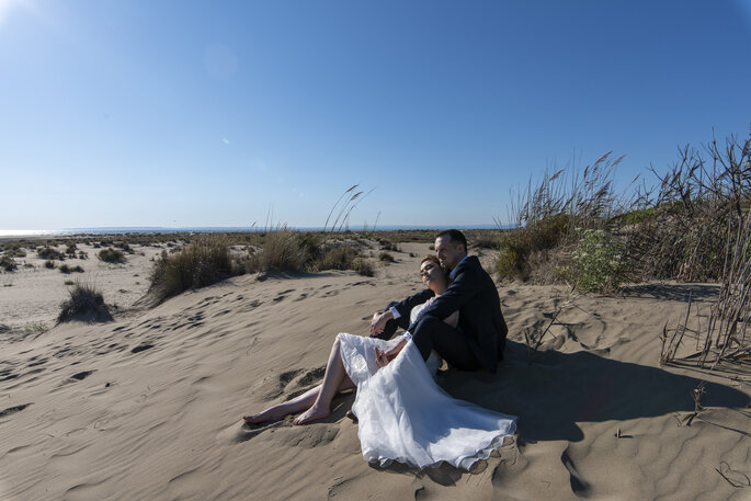 Des mariés assis sur la plage