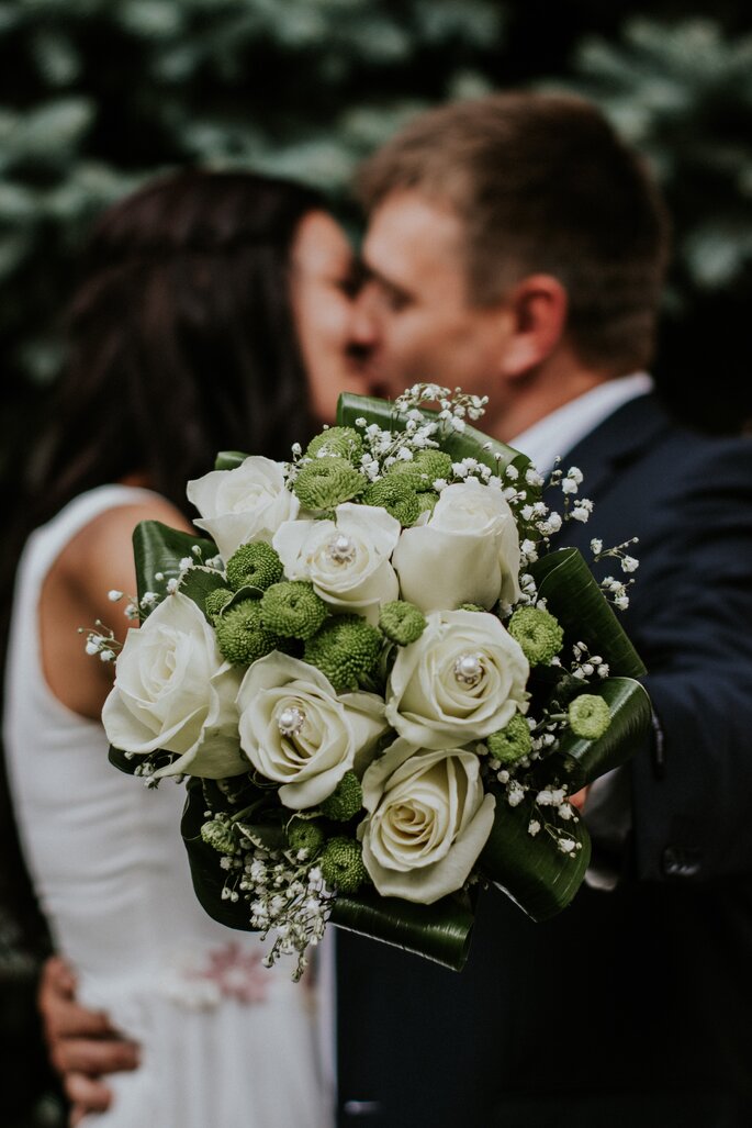 Bukiet ślubny z białych róż z dodatkiem zielonych liści i gipsówki