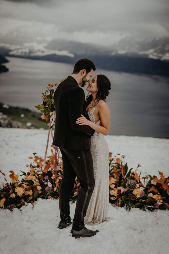 Brautpaar vor Schneekulisse mit Blumen
